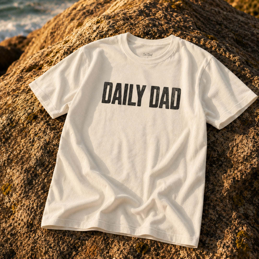 Close-up of the Natural Daily Dad Tee on a woven outdoor surface — EvoDad Co.